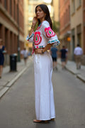Conjunto blanco de algodón de Iciar y Candela by Creasur S.L. con top corto bordado y pantalones palazzo anchos.