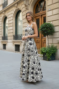 Iciar y Candela by Creasur S.L. vestido maxi floral escote cuadrado sin mangas, tejido ligero, fondo crema y estampado negro.