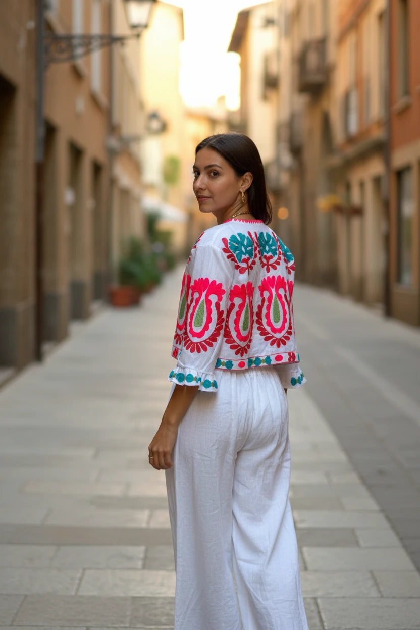 Conjunto blanco de dos piezas de Iciar y Candela by Creasur S.L. con top corto bordado y pantalones palazzo anchos.